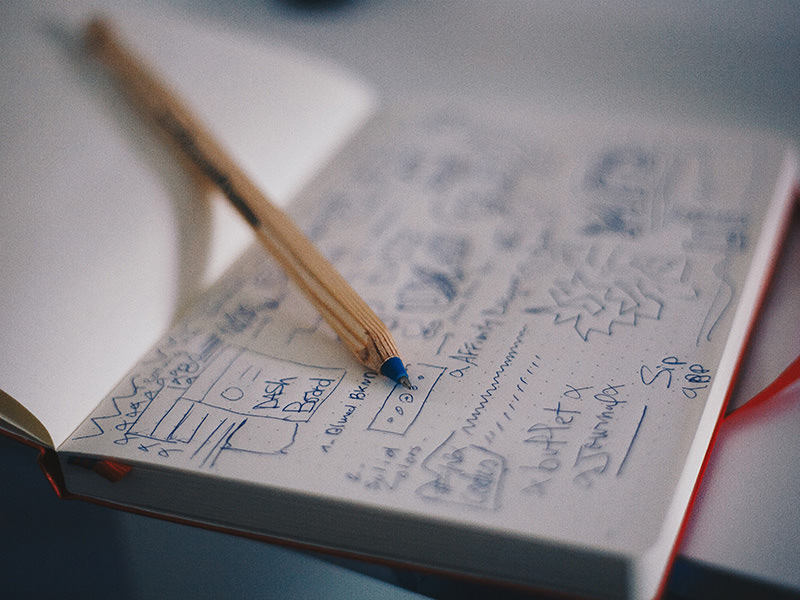 A sketch of a website wireframe in a red notebook